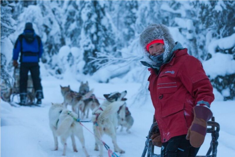 Vrouw met warme kleding tijdens huskytocht - paklijst Fins Lapland 