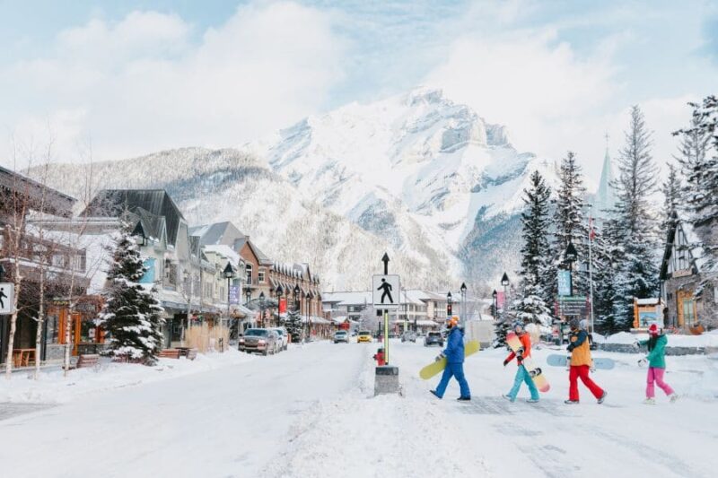 Vier mensen steken de weg over in wintersportgebied Banff in Canada