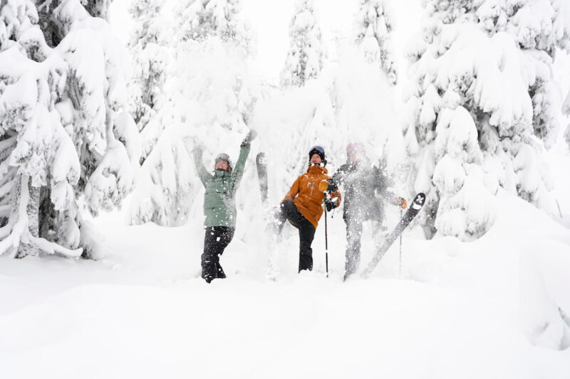 Twee mensen gooien poedersneeuw omhoog op de sneeuwzekere pistes van Trysil, Noorwegen