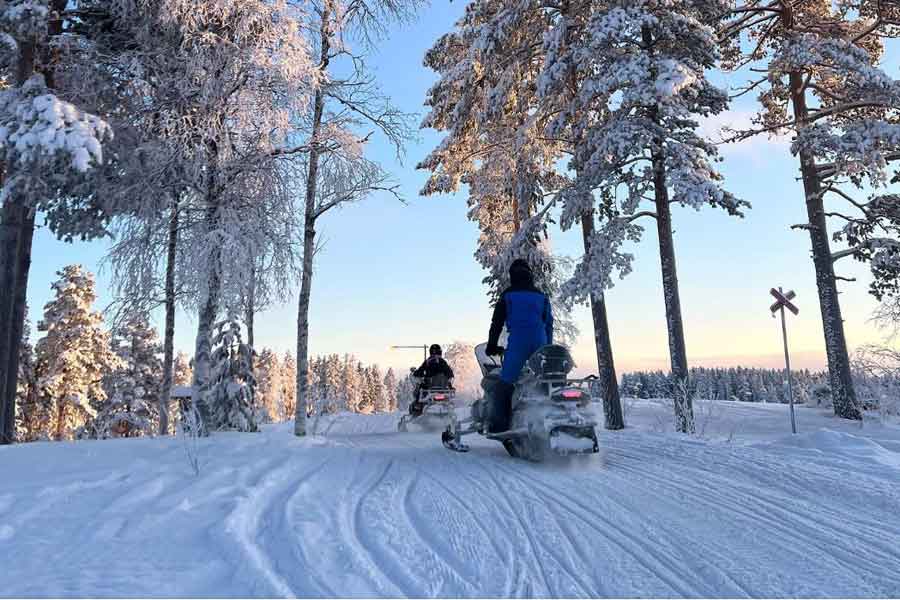 Sneeuwscooterrijders op de berg in de zon in Sälen