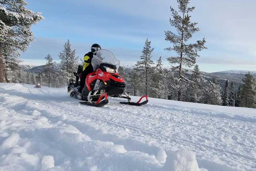 Sneeuwscooterrijders op de berg in de zon in Sälen